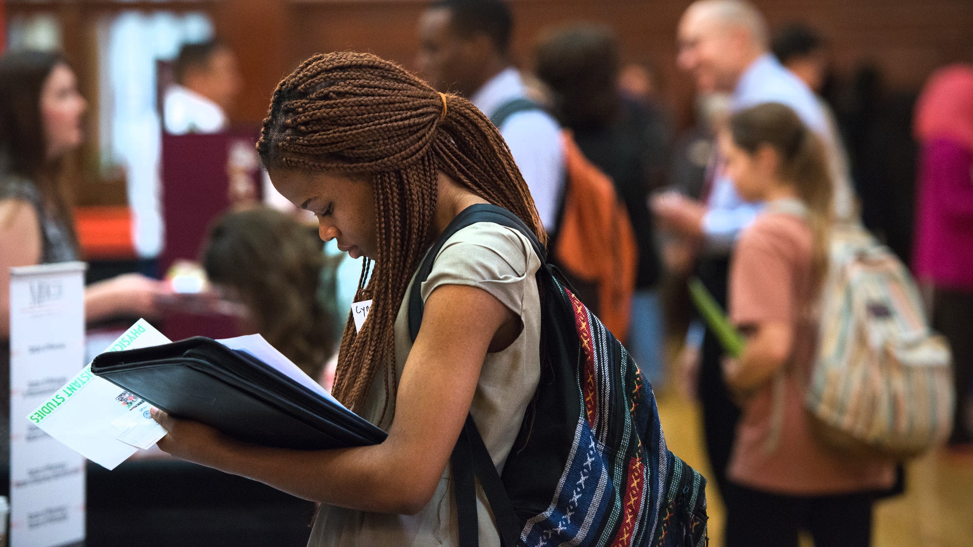 Woman in a crowd taking notes at a conference