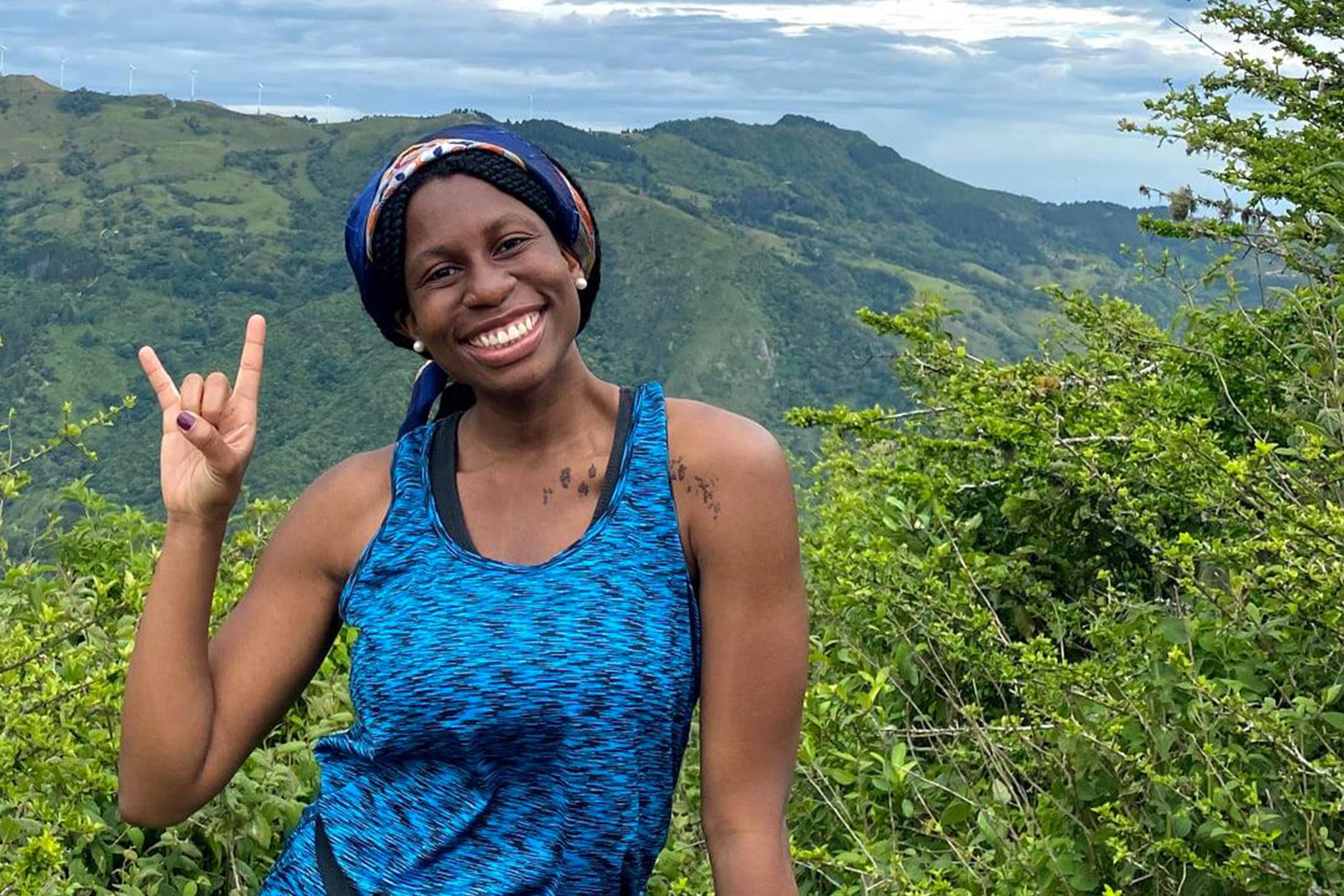Student giving the Hook 'em hand gesture in a mountainous region of Costa Rica