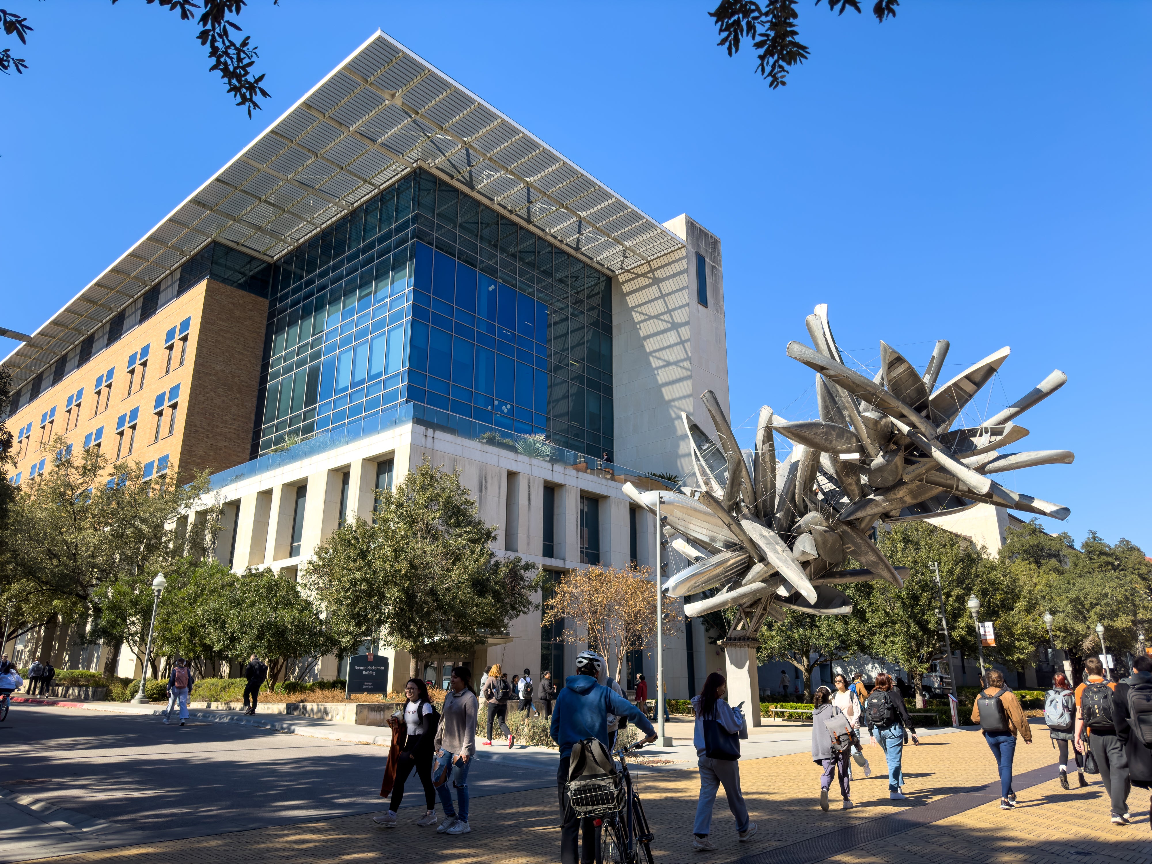 Photo of Norman Hackerman Building (NHB) with "Monochrome" canoe sculpture and students