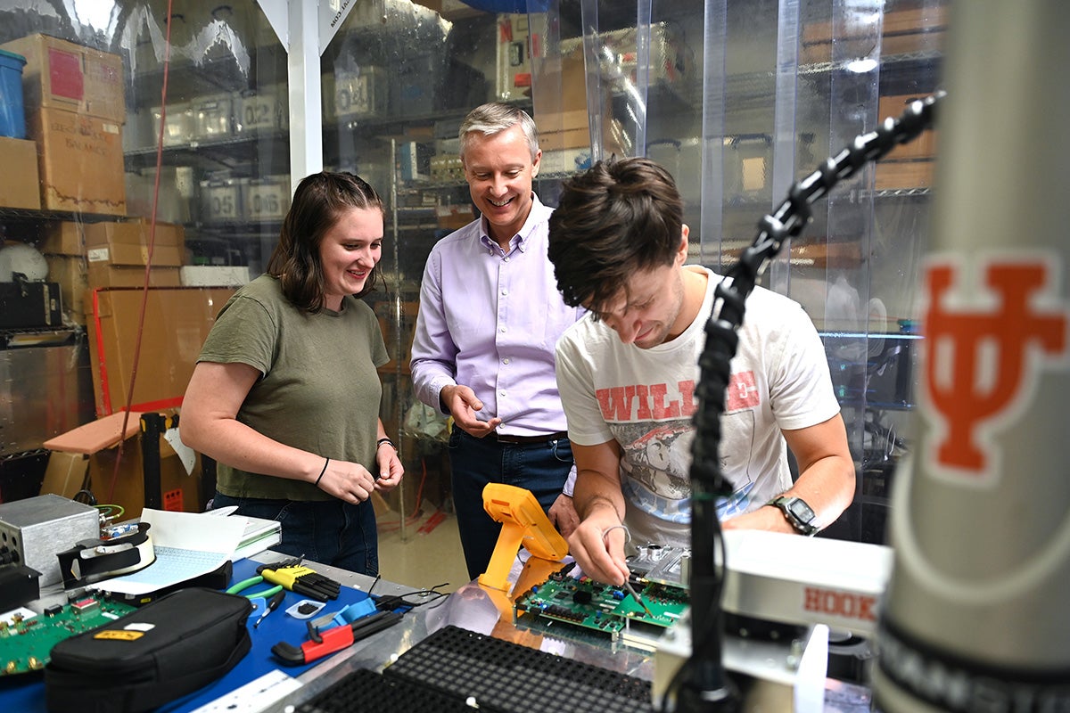 Three scientists working in a lab with electronics
