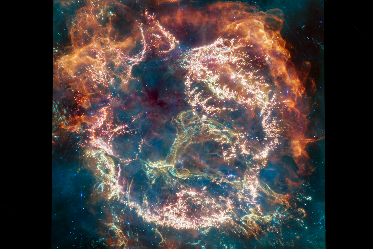 Wisps of colorful gas and dust in a telescope image showing the remains of a supernova explosion