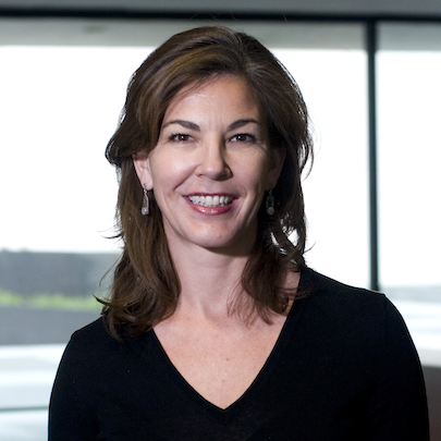 A woman in a v-neck shirt smiles.