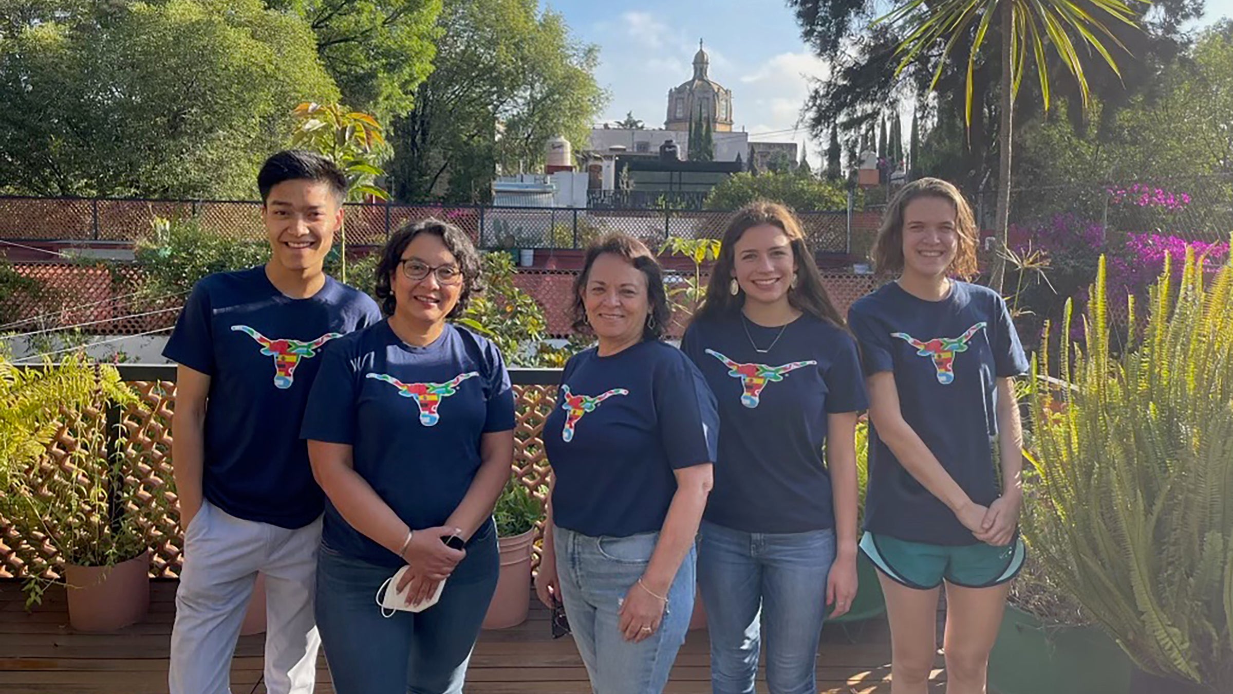 A group of five people wearing blue tshirts with univesity of texas longhorn logos