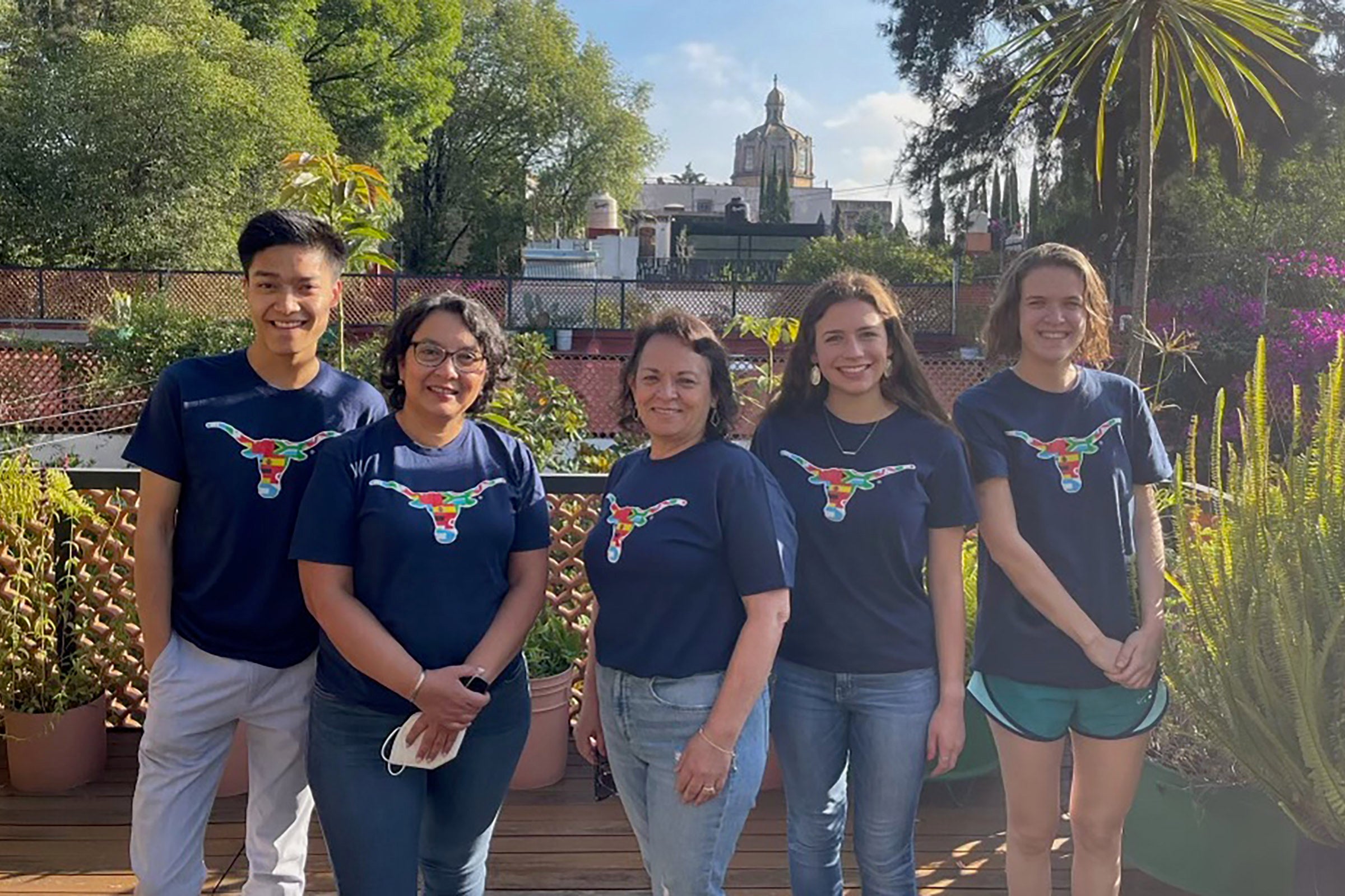 A group of five people wearing blue tshirts with univesity of texas longhorn logos