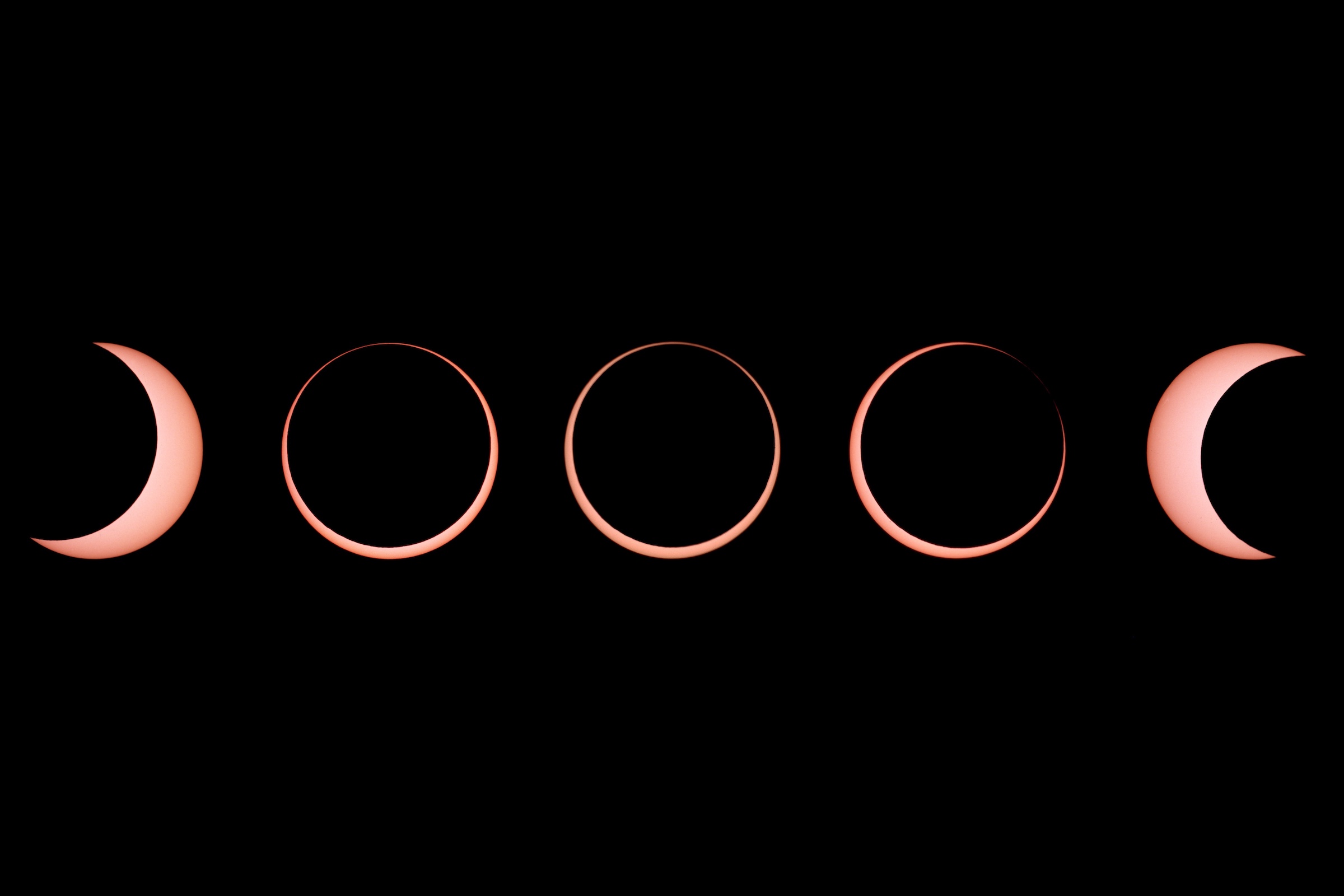 A solar eclipse is shown at five stages with the moon blocking out most of the sun and leaving a ring of light at its most extreme phase