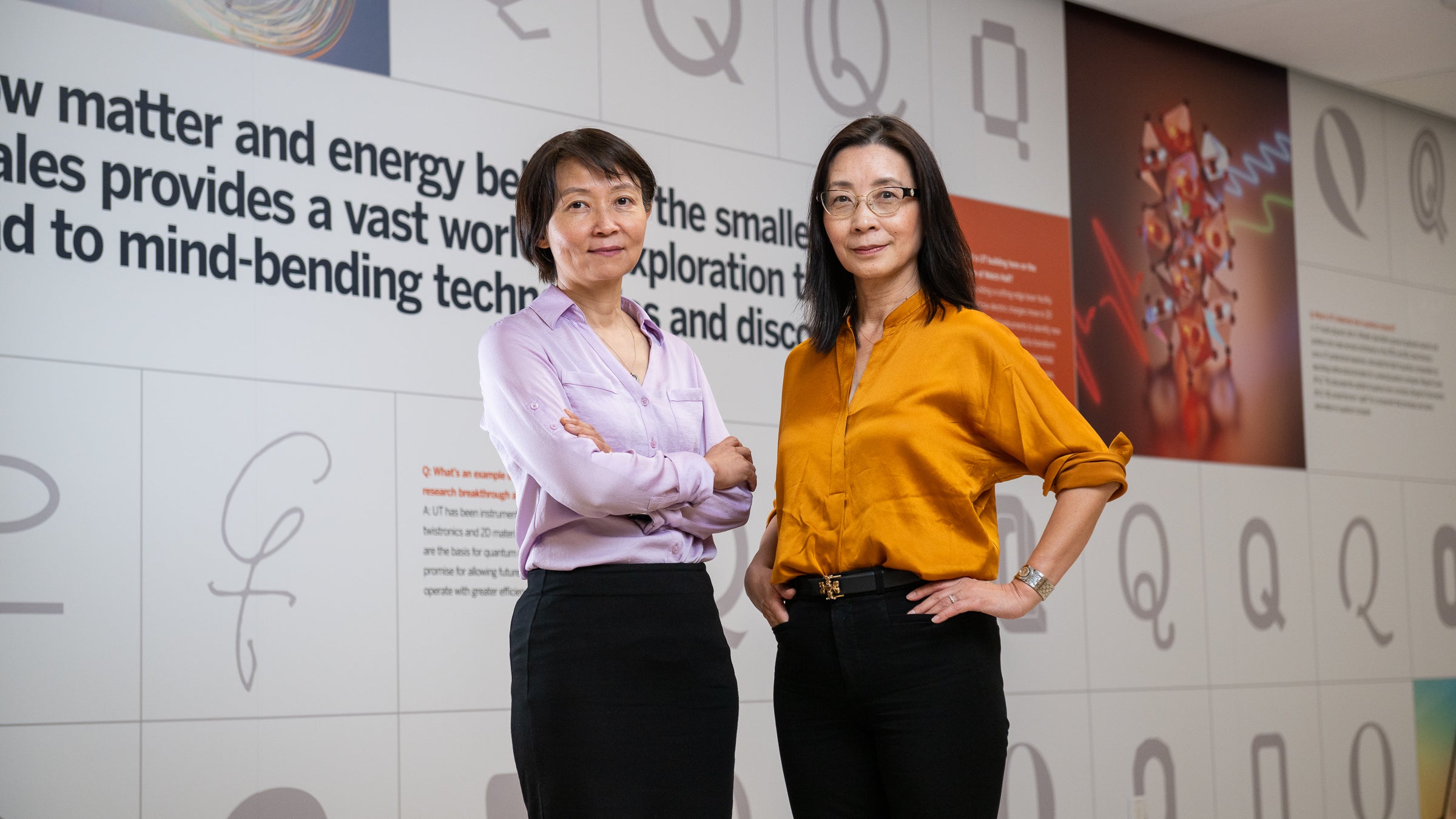 Two female scientists stand in front of a display about quantum science. Photo by Eileen Chong.