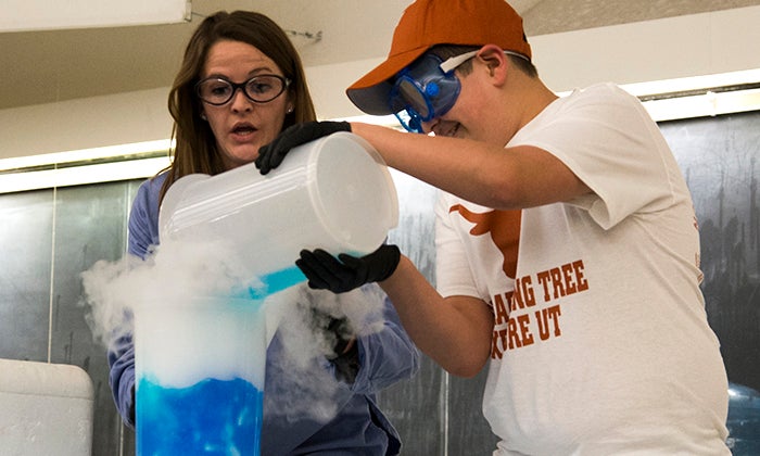 A volunteer from the crowd assists Dr. Biberdorf at Explore UT. Photo by Jeff Mertz.