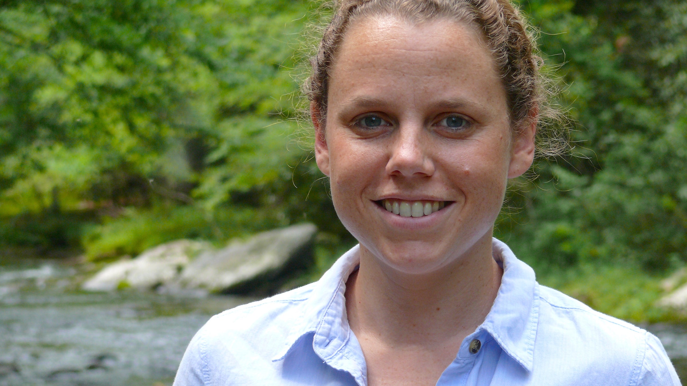 Portrait of a woman in front of a stream