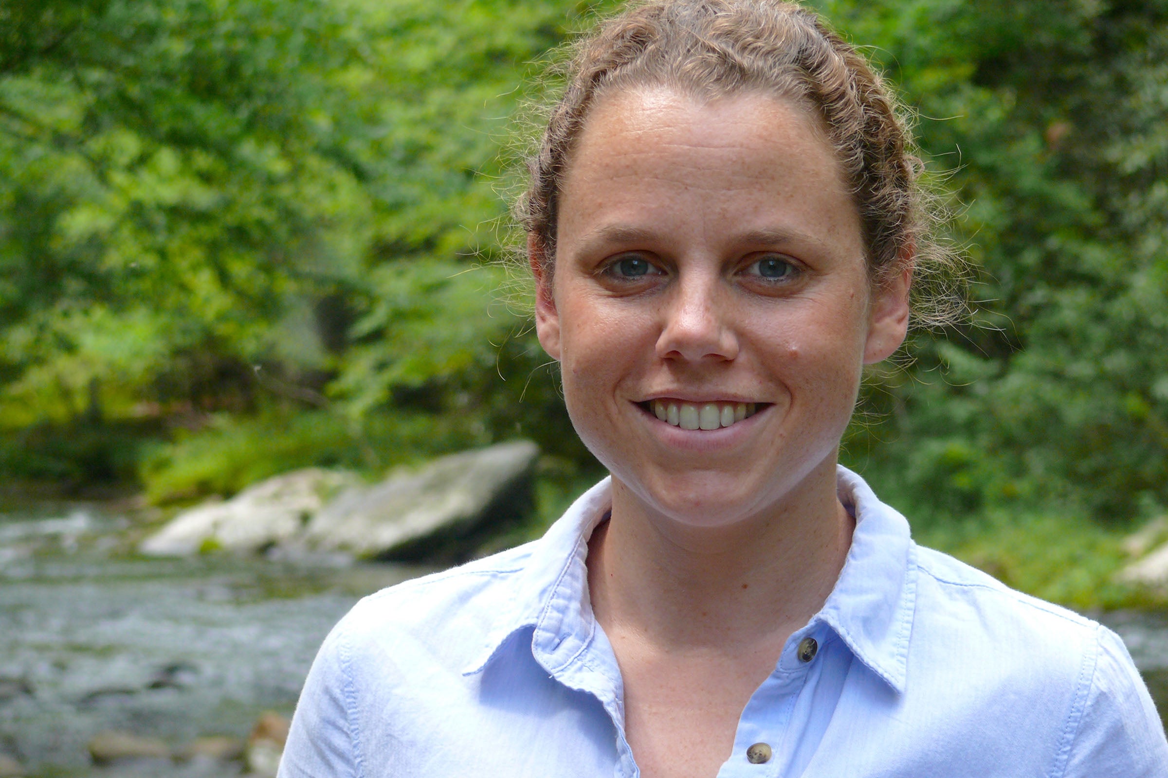 Portrait of a woman in front of a stream