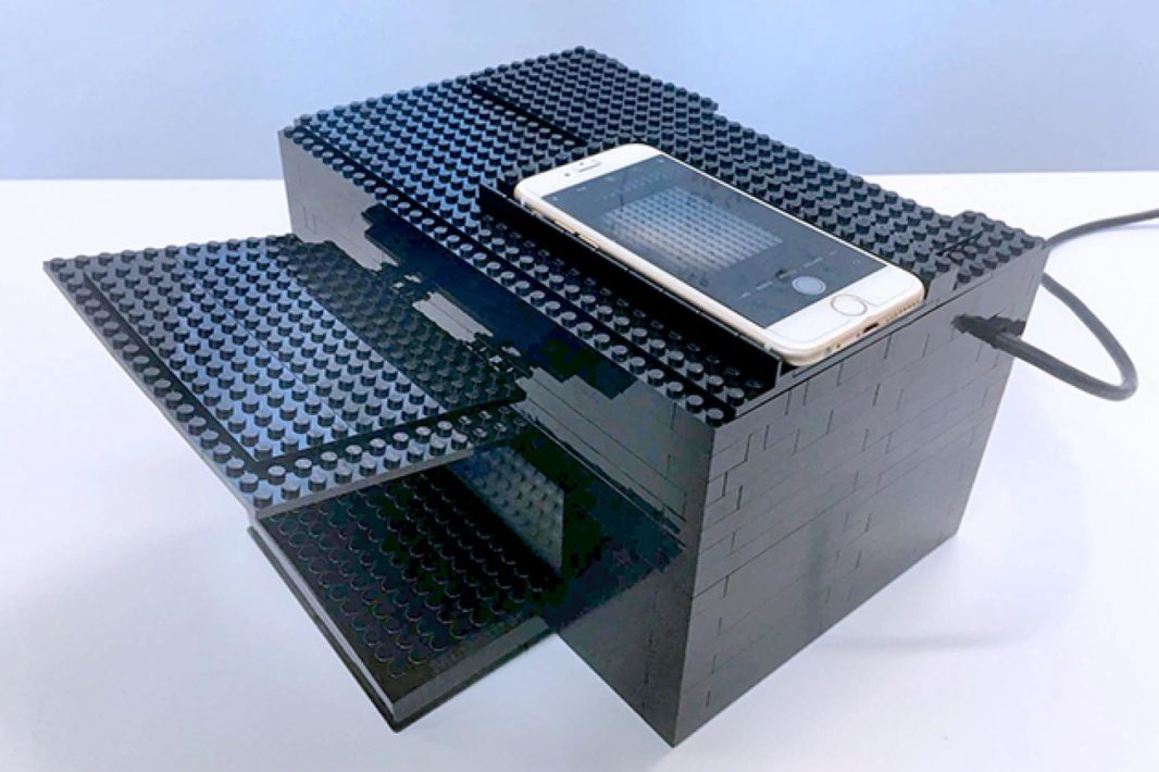 A black lego box with a smartphone sitting on top