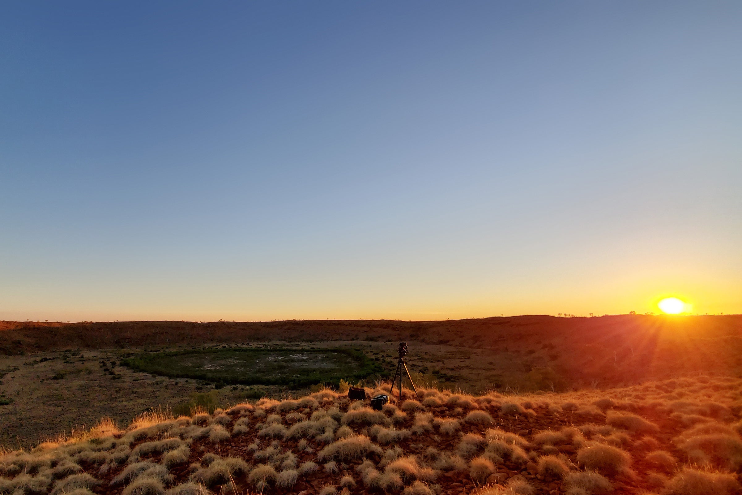 Sun setting over impact crater