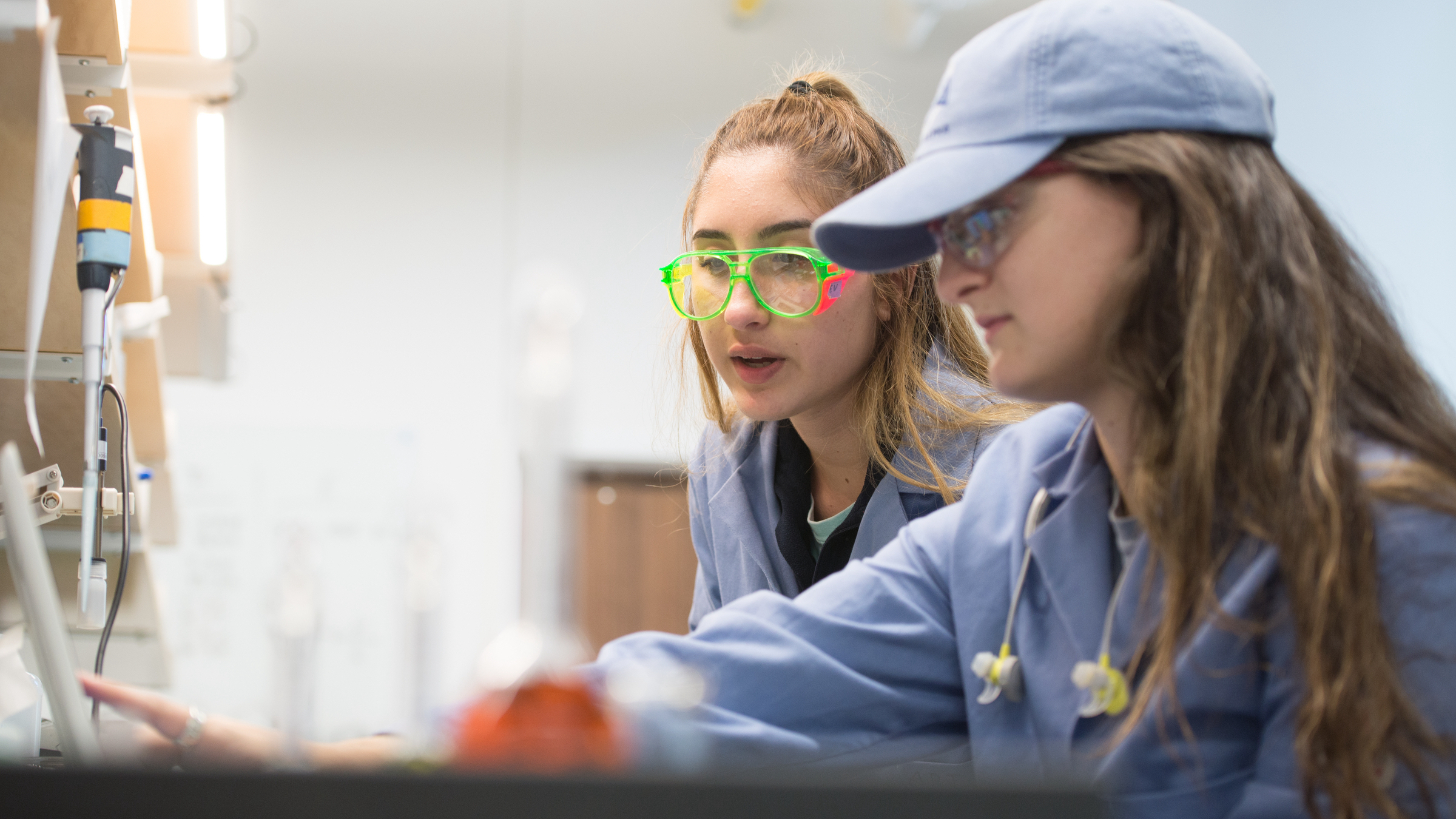 FRI researchers in a lab wearing goggles point to a finding