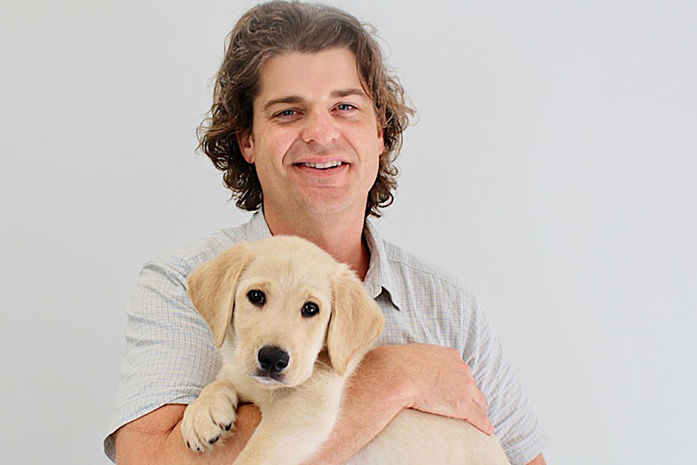 Brian Hare holding a puppy.