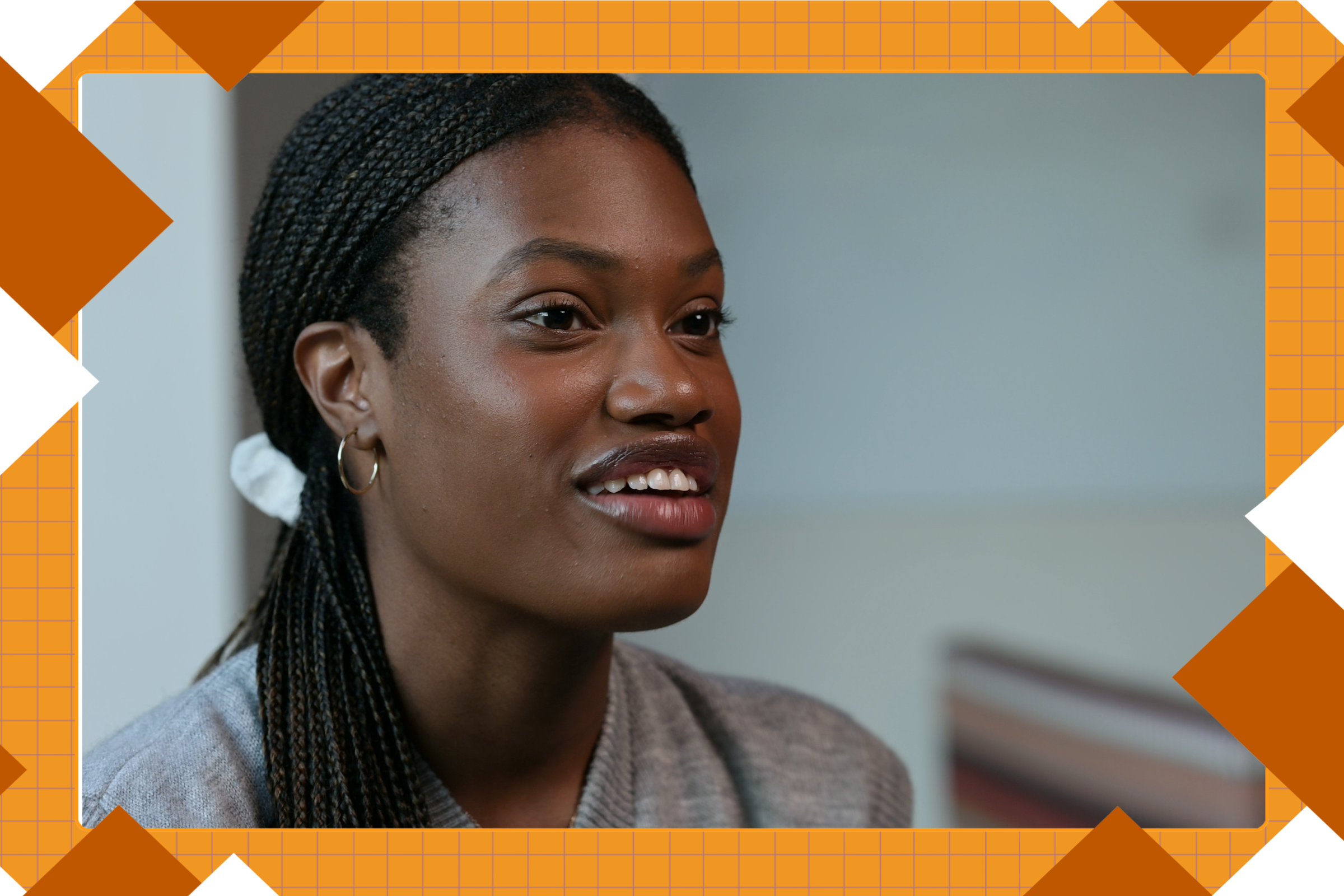 A student with a ponytail smiles while discussing her research, her face framed by burnt orange graphics. 