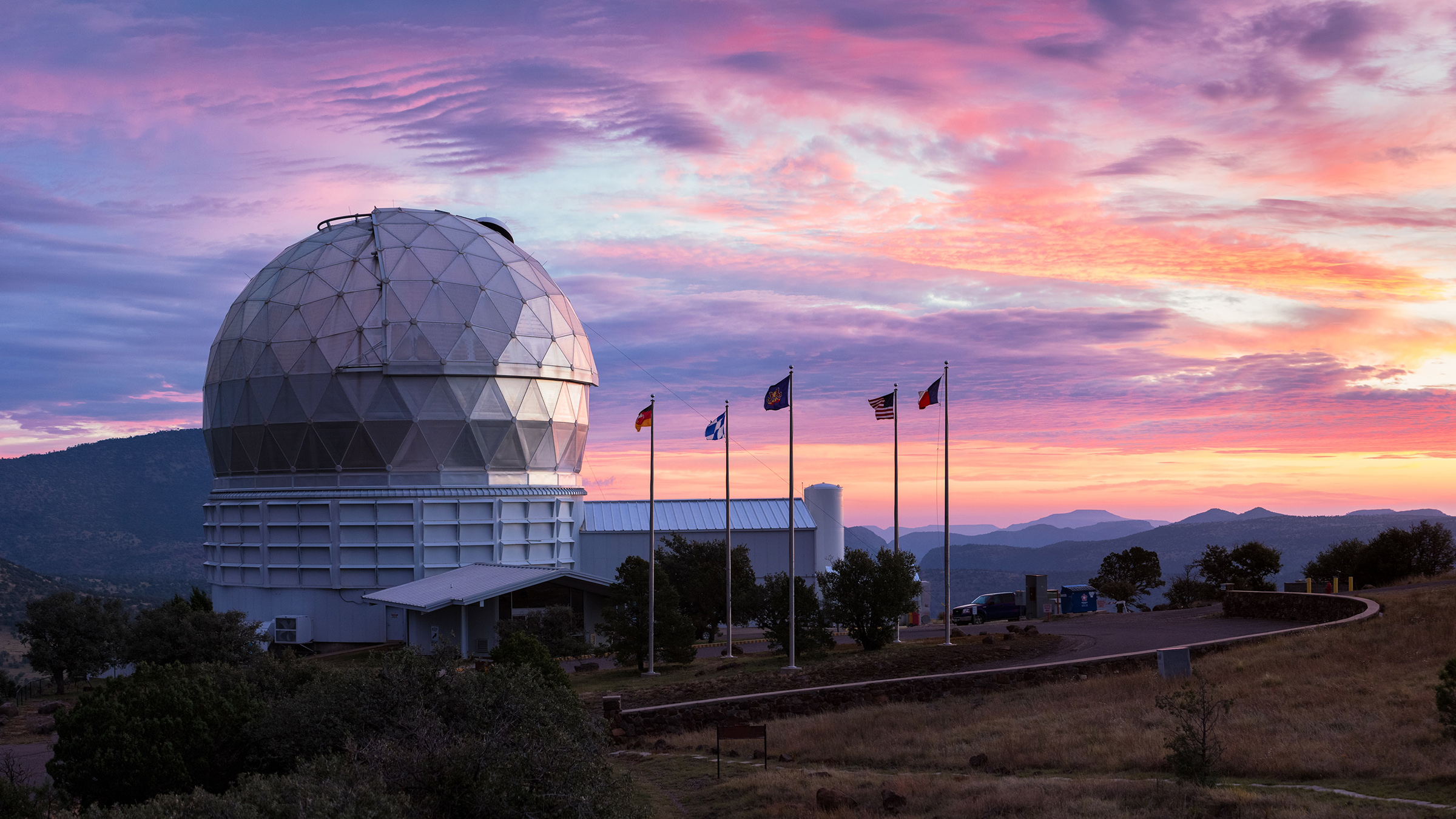 A telescope dome in front of a colorful sunset