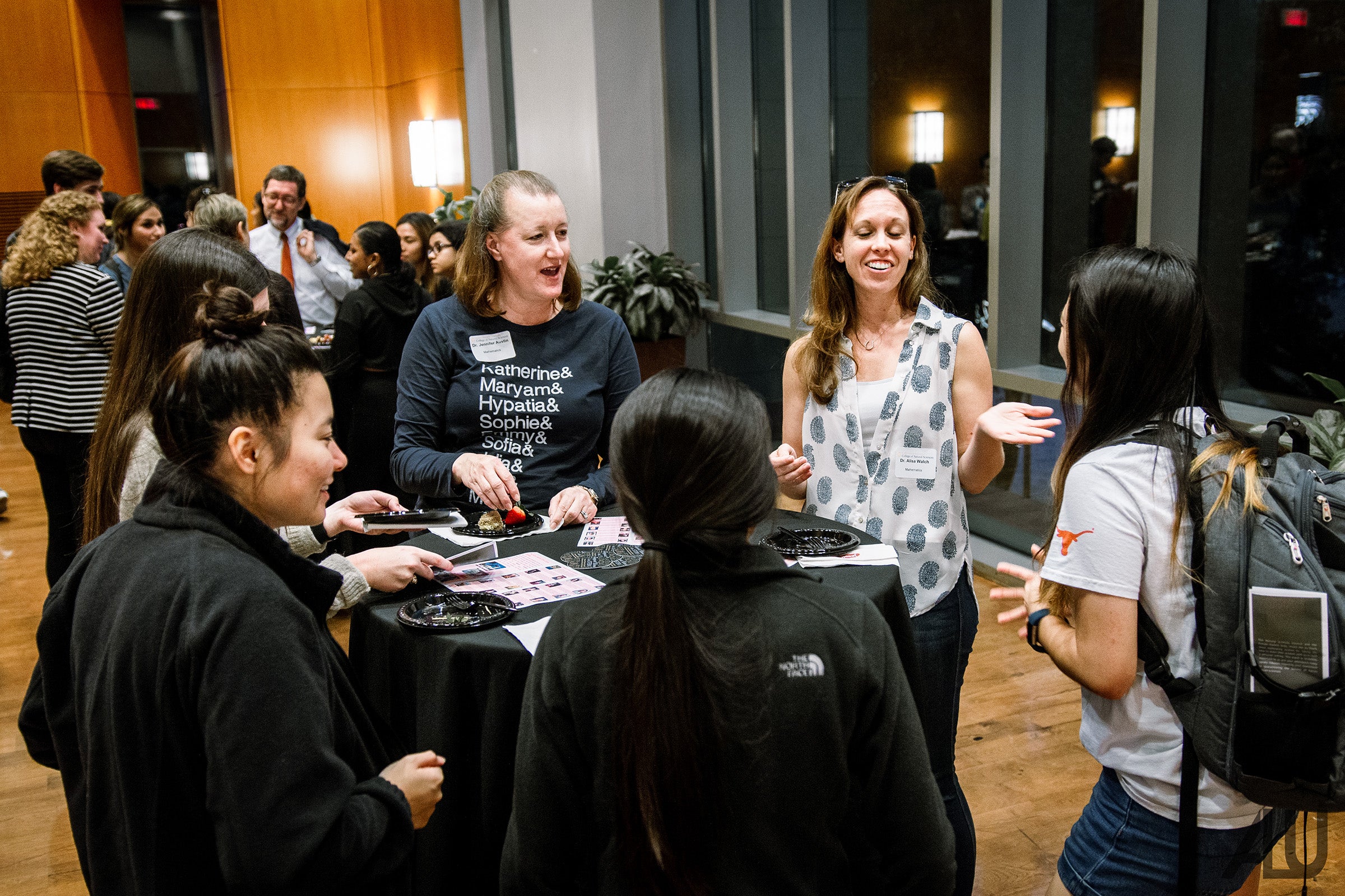 Students and professors in conversation around a table