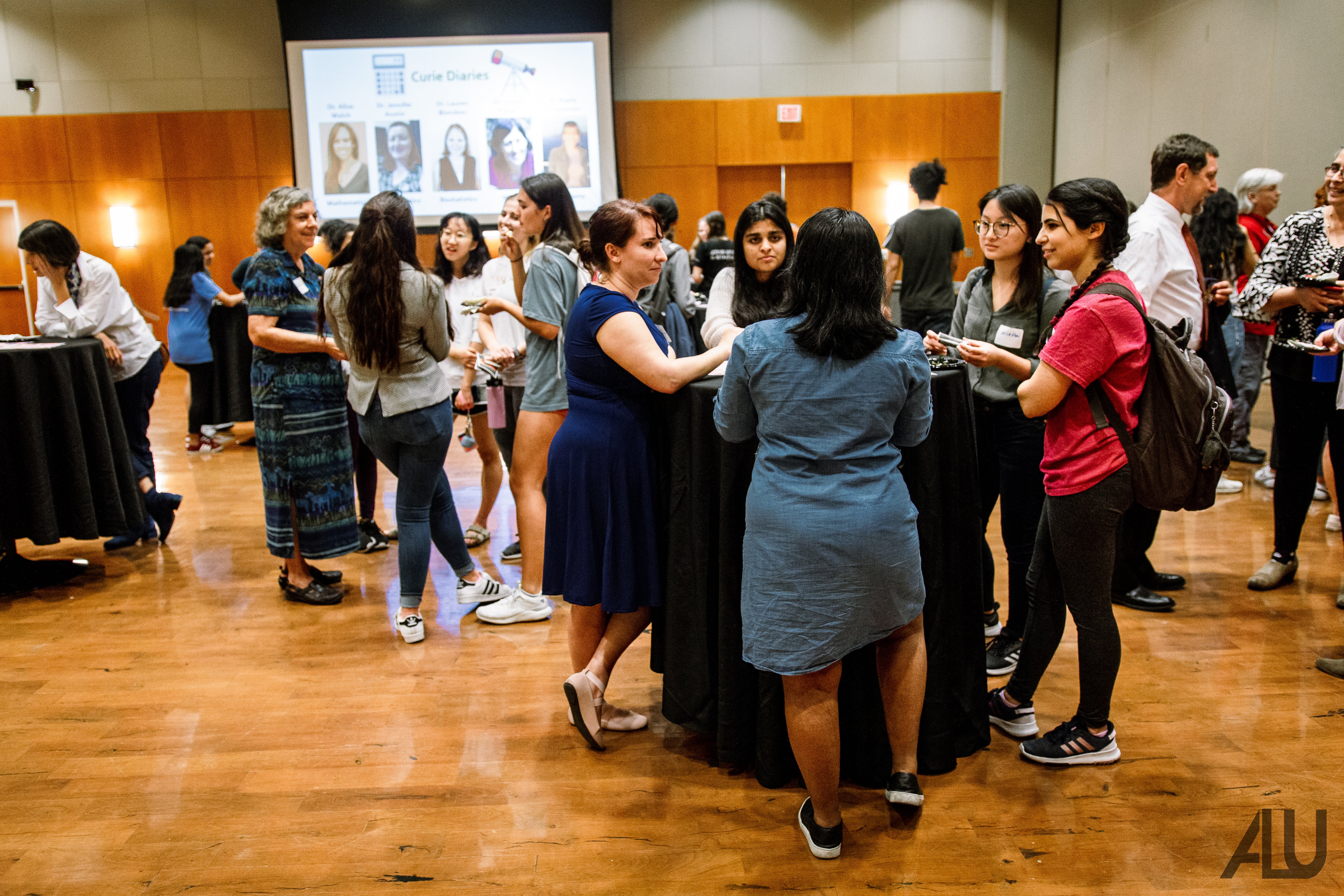 Groups of women gathered in conversation in a conference room