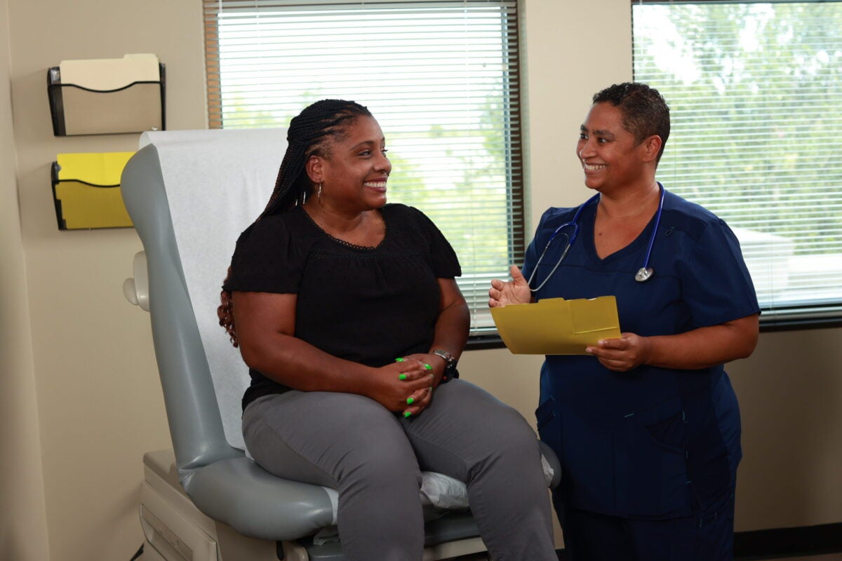 A doctor talks to a patient as both are smiling