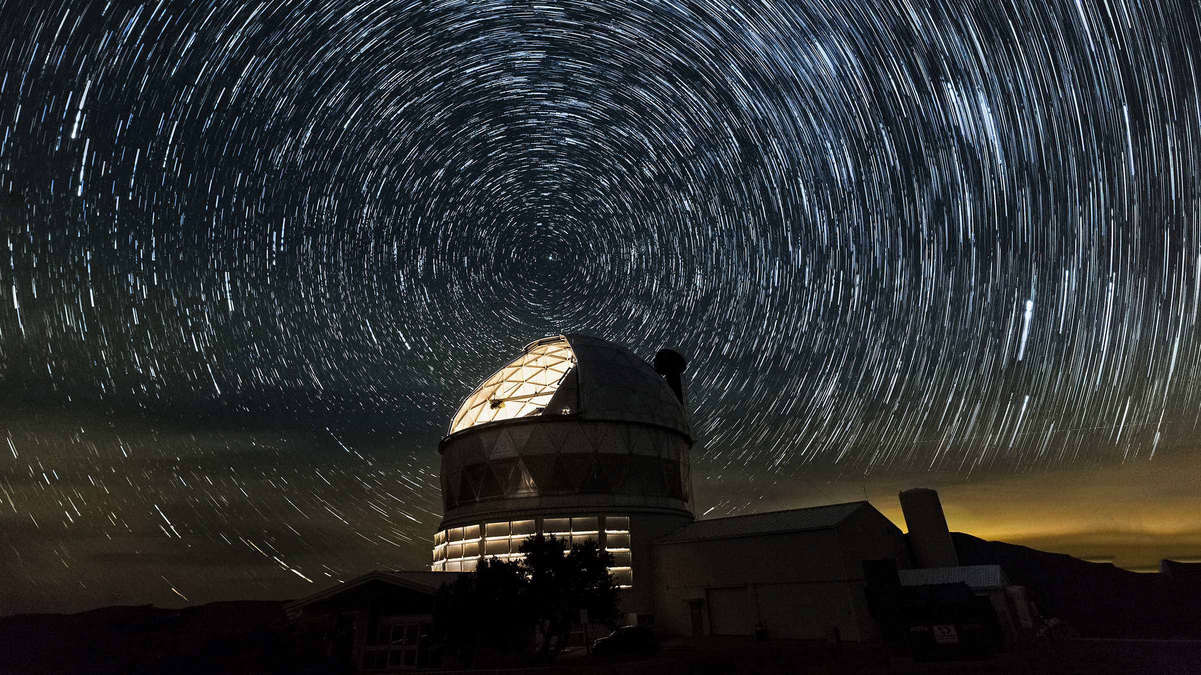 A telescope dome glows under a starry sky