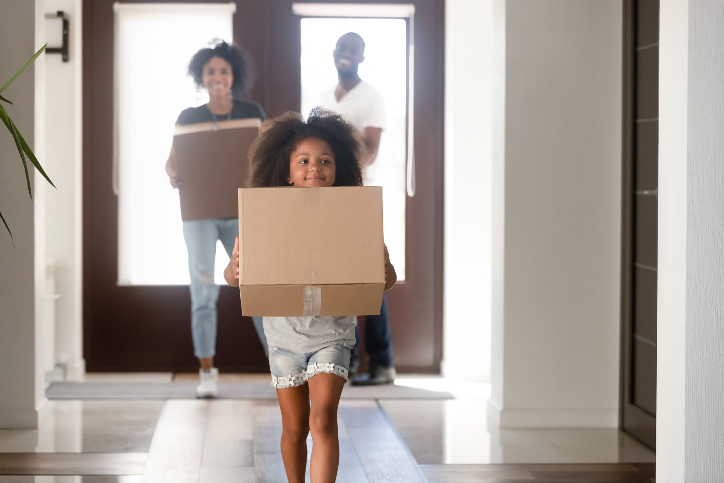 A family carries boxes into their new home