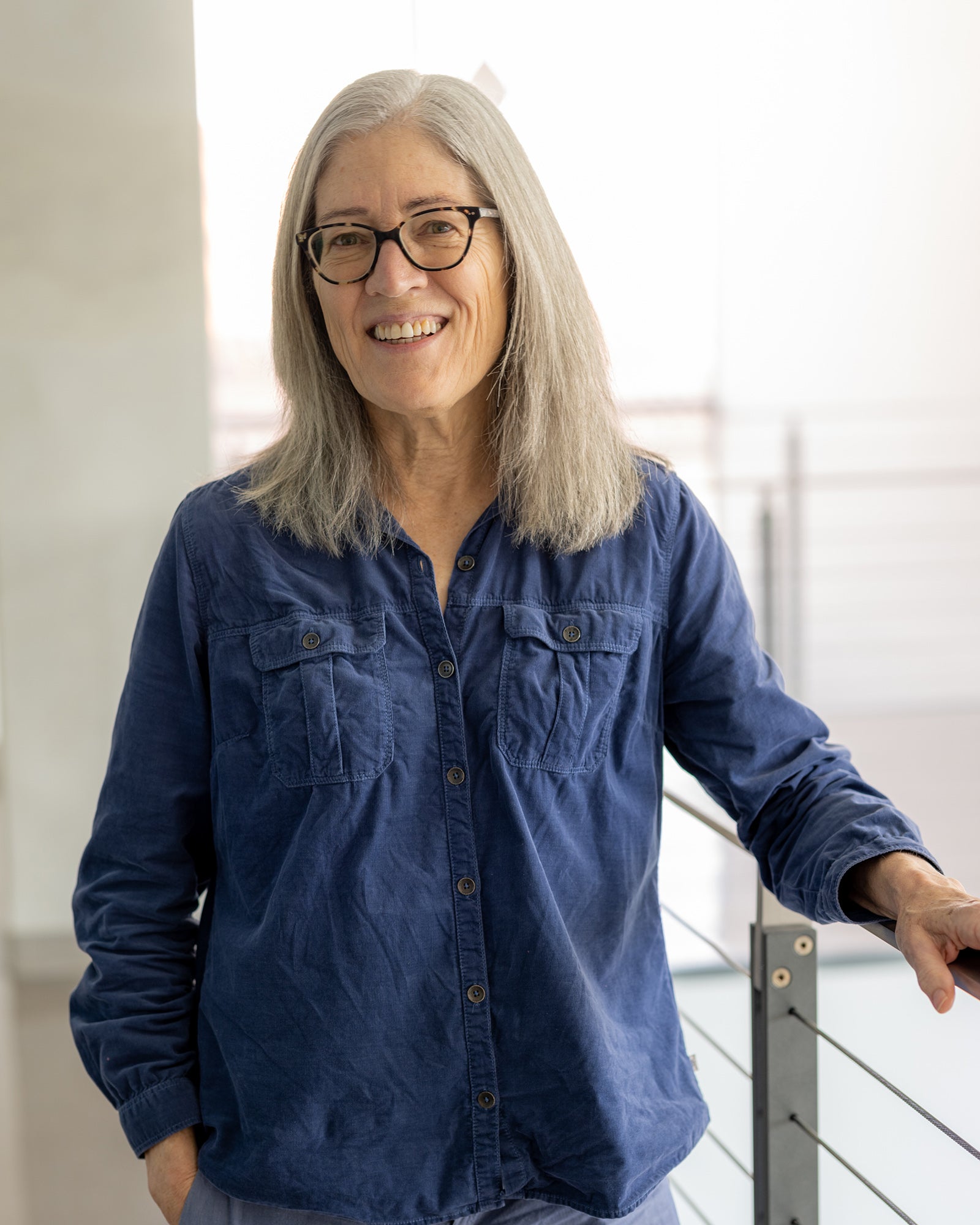 Portrait of a woman in a blue shirt and glasses