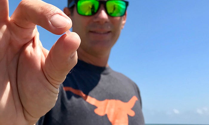 Jace Tunnell holds a plastic nurdle between thumb and forefinger