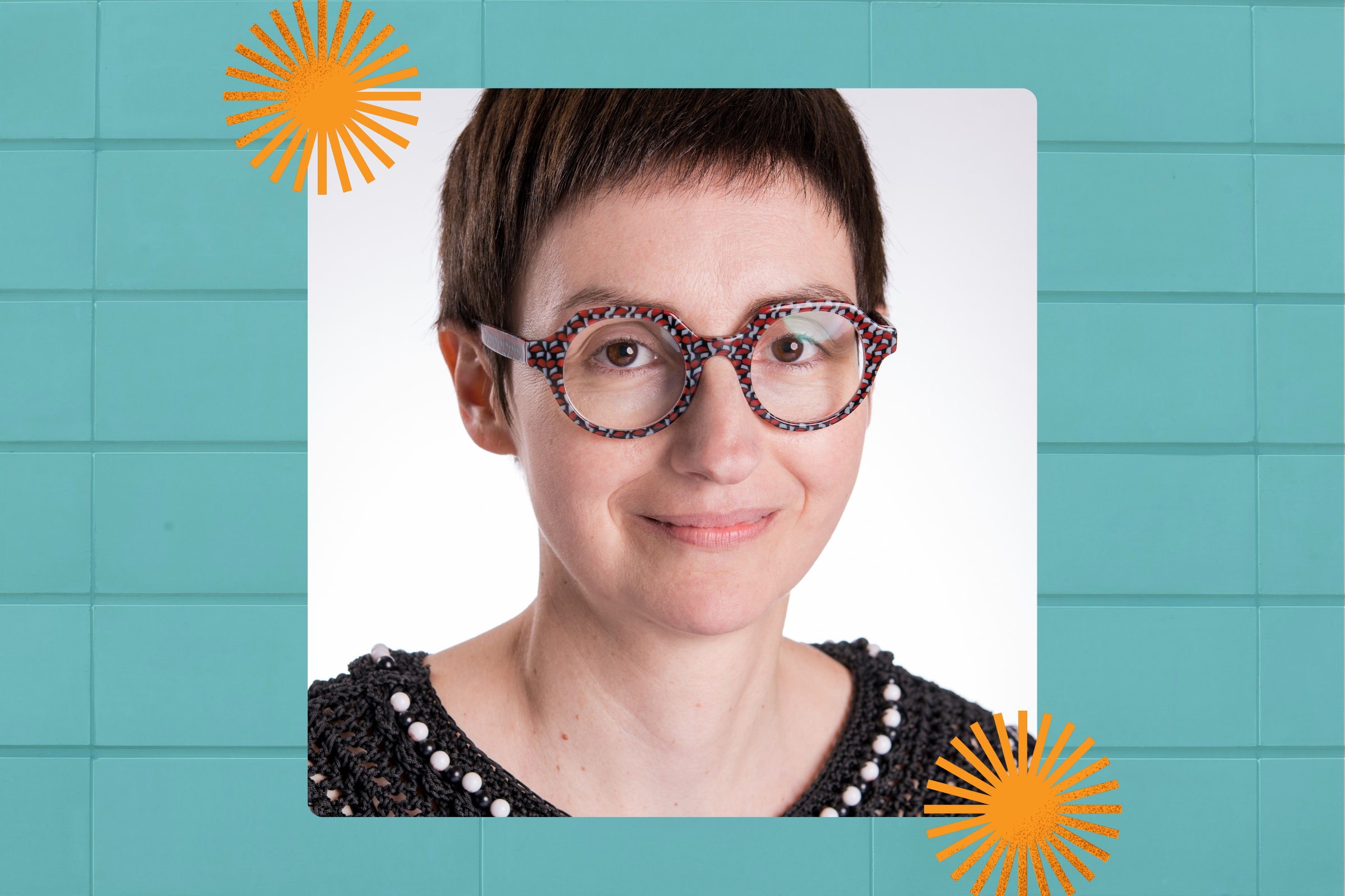 Portrait of a woman with short dark hair, wearing glasses and a dark shirt