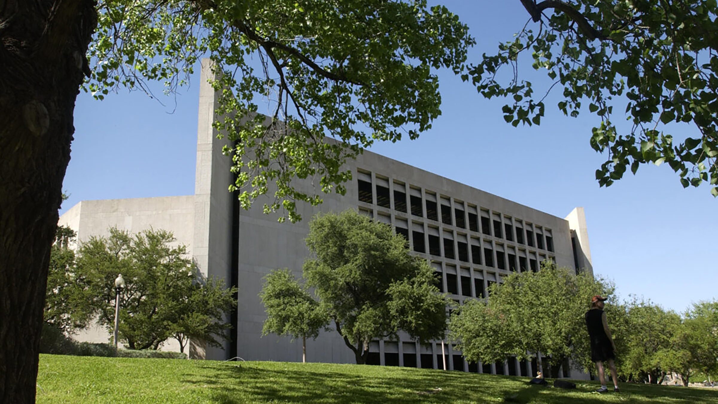 A multistory building on a university campus surrounded by trees