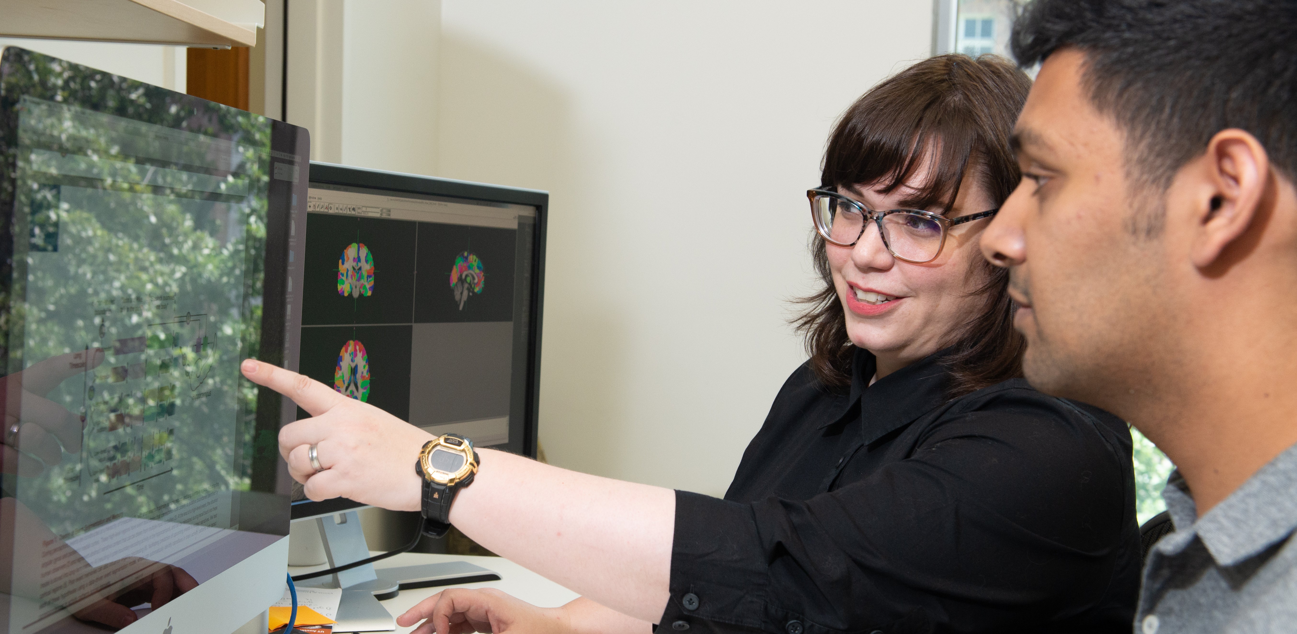 Professor pointing at screen with student next to her