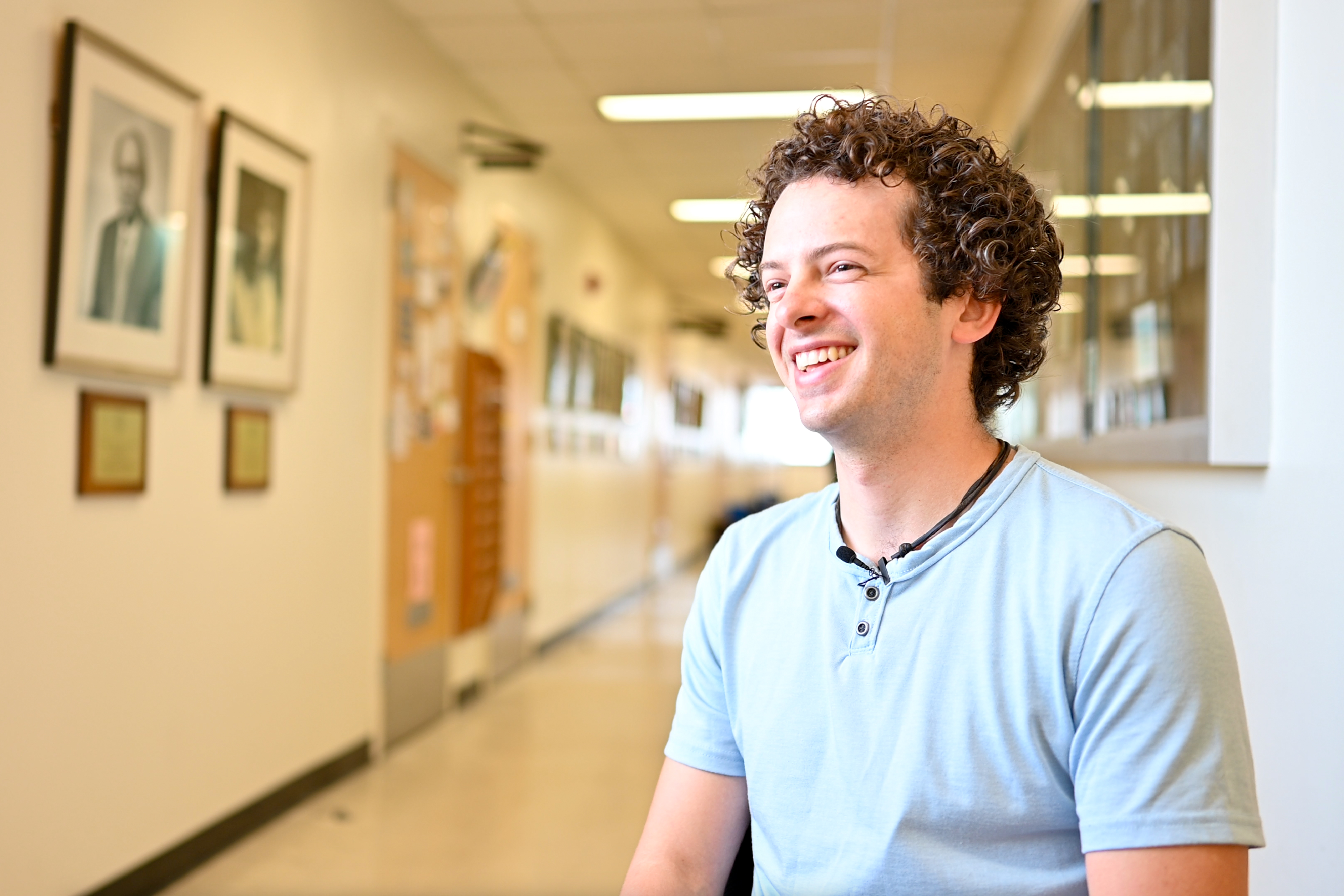 A smiling student with curly brown hair
