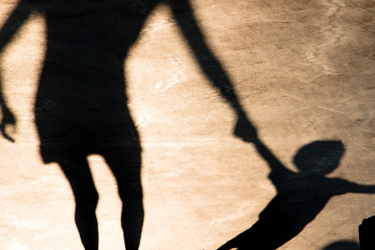Photo of a shadow of an adult holding the hand of a child