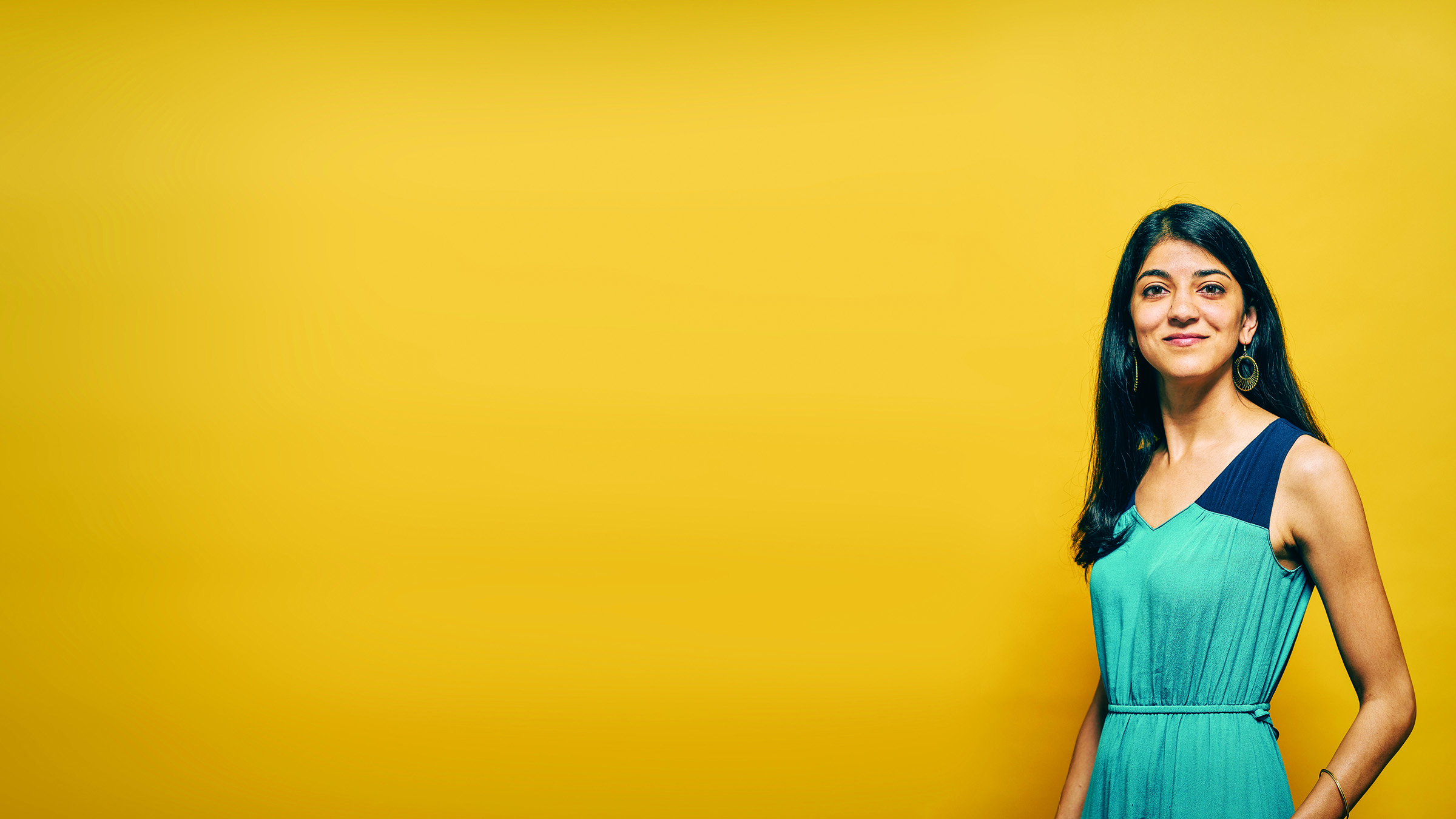 Portrait of a woman in blue dress in front of a yellow background