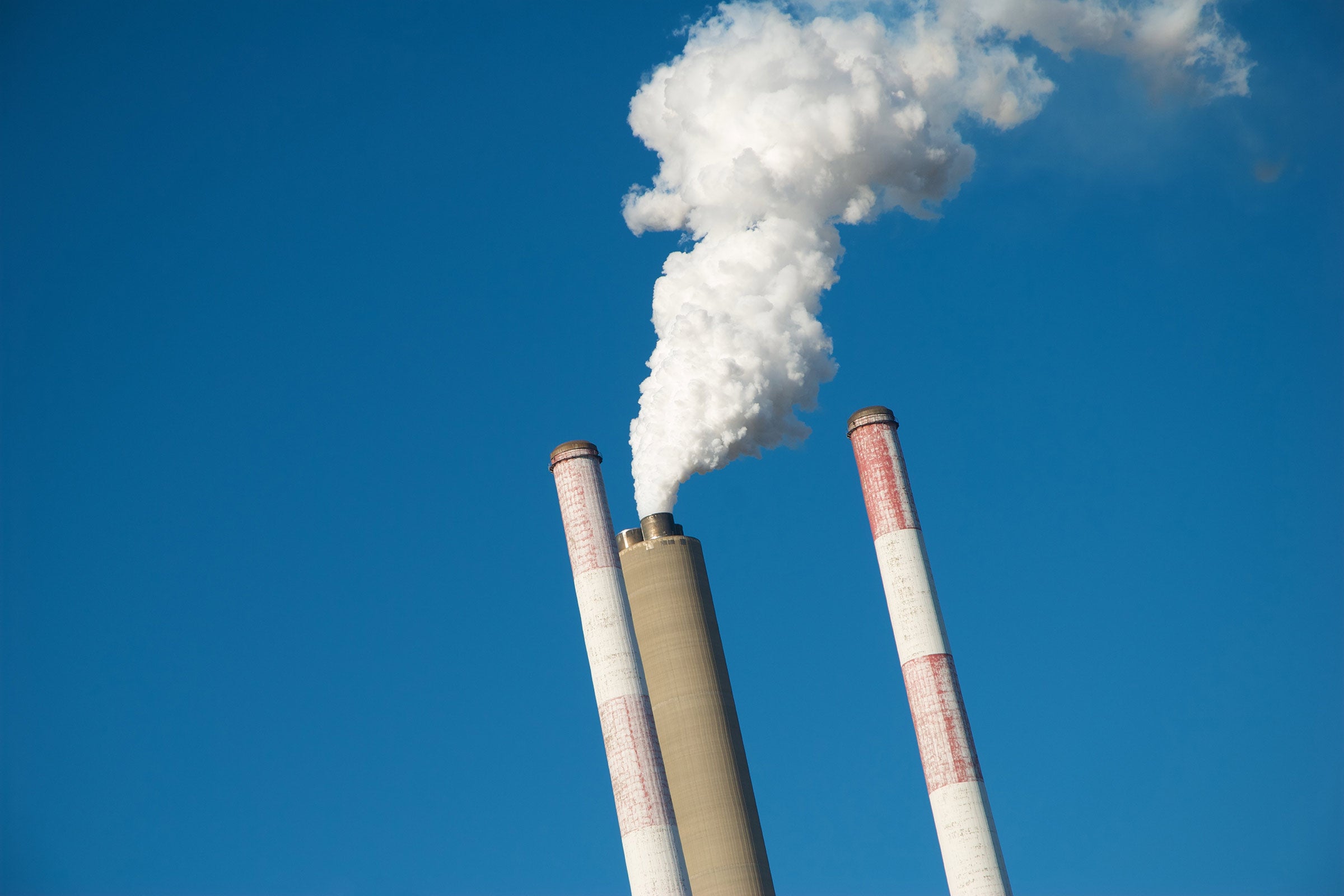 A white plume of exhaust spews from power plant smokestacks