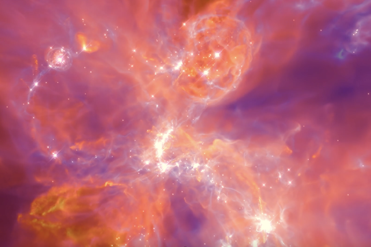 Stars form in a gaseous environment in deep space with explosions of warm and cool colors