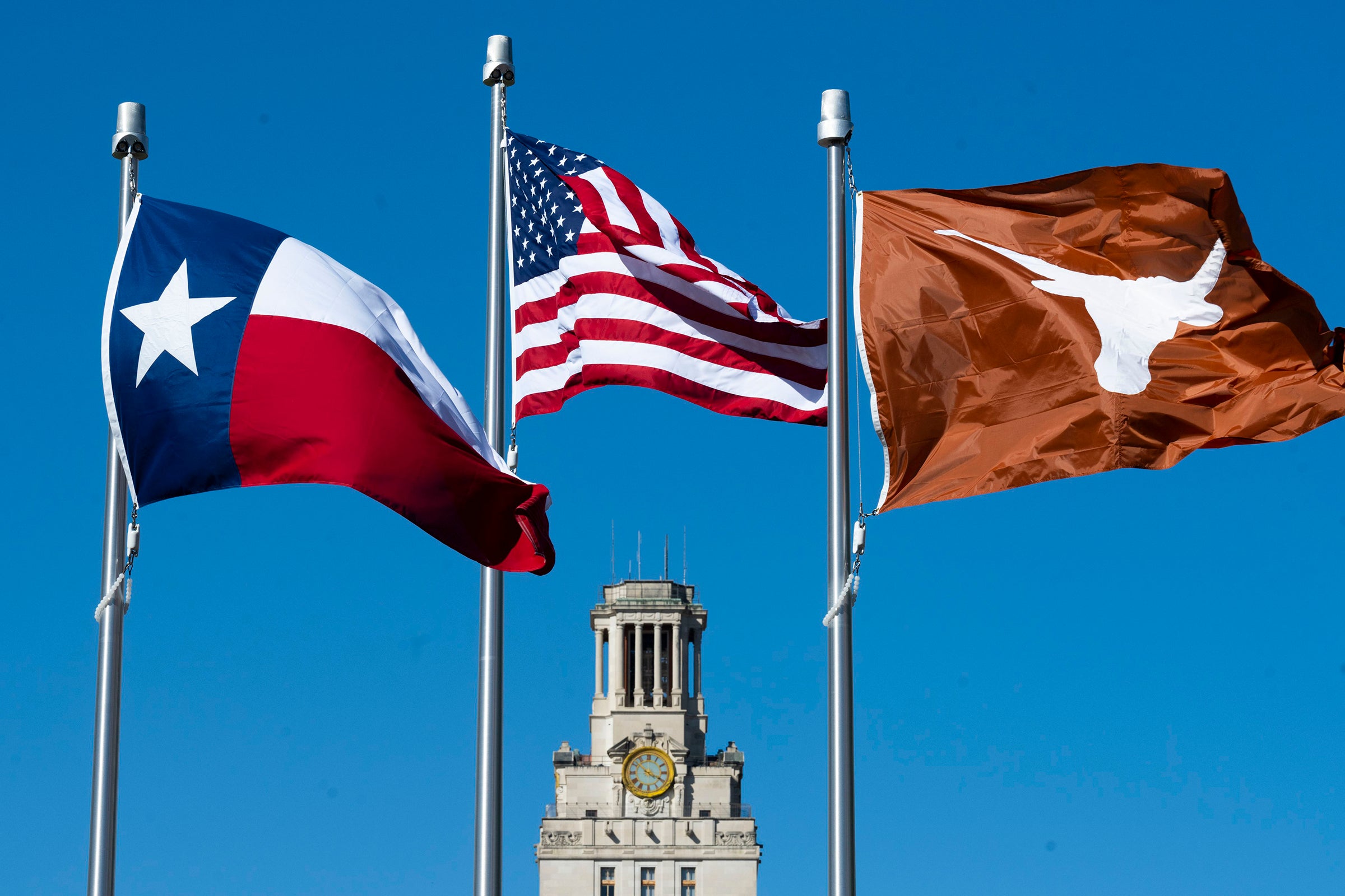 Texas, United States of America and UT flags flying in front of the UT Tower