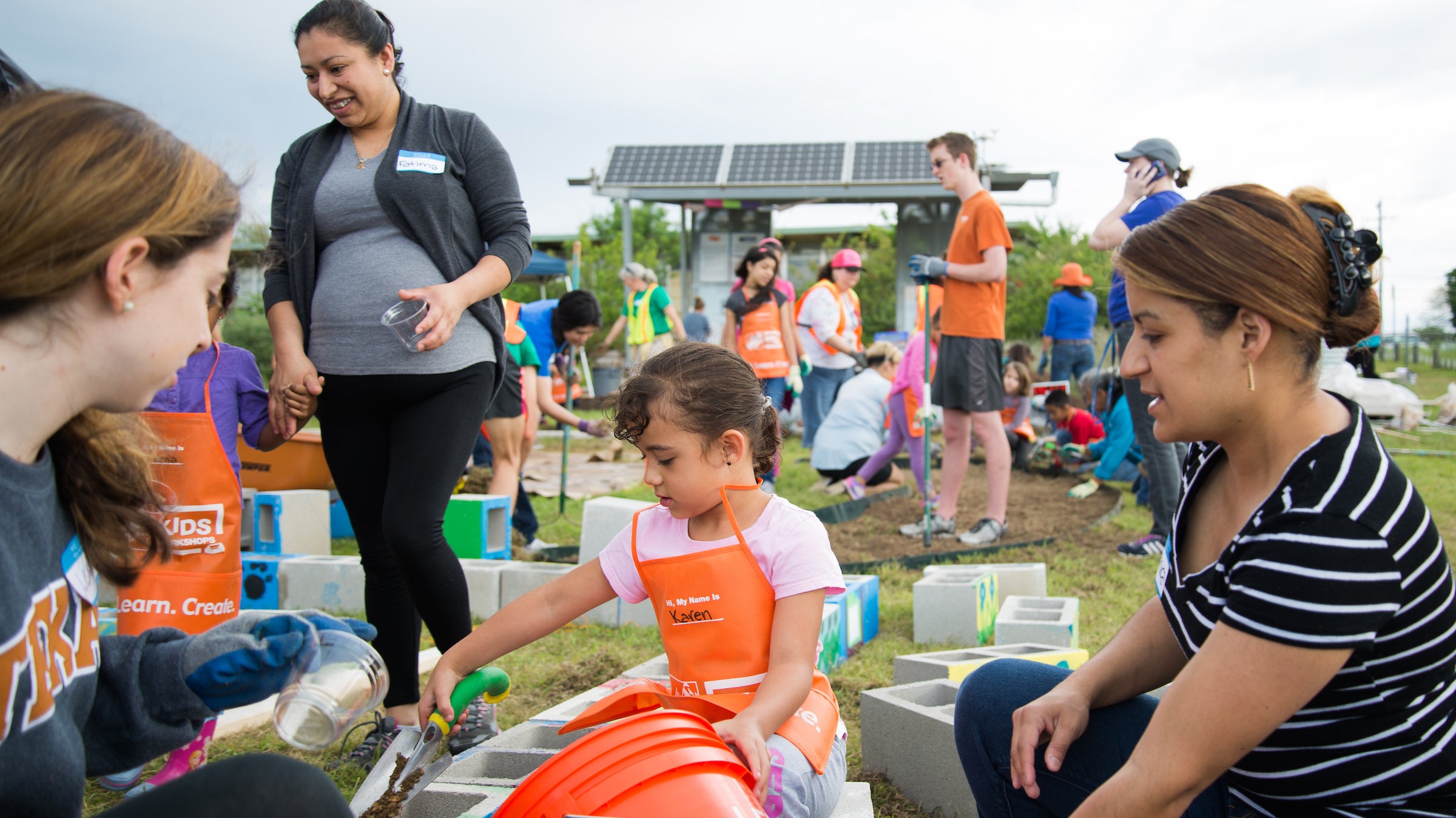 Adults and children work together on building school gardens with TX Sprouts