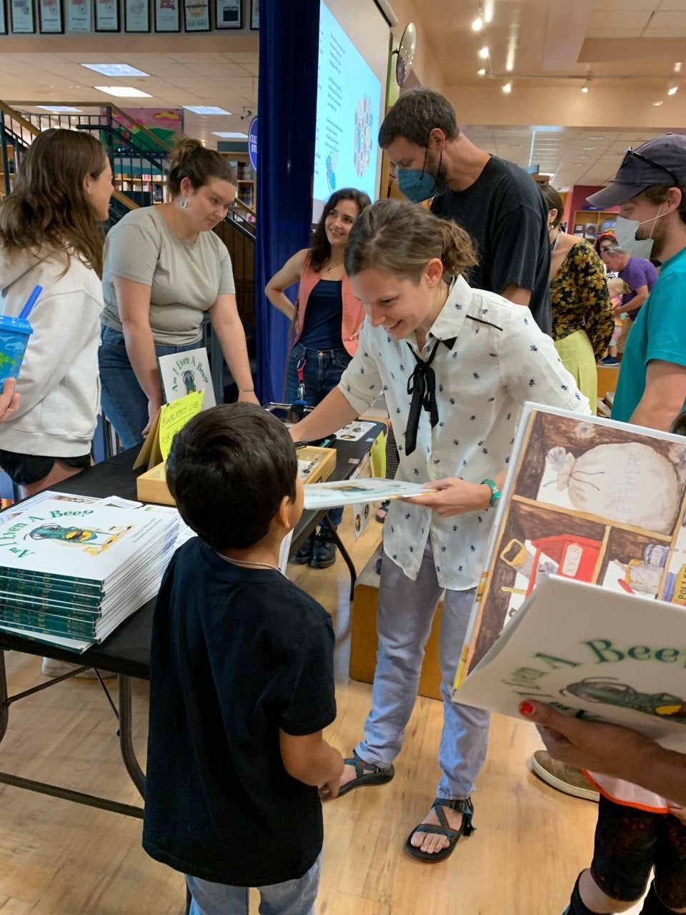 A woman signs a book in a store