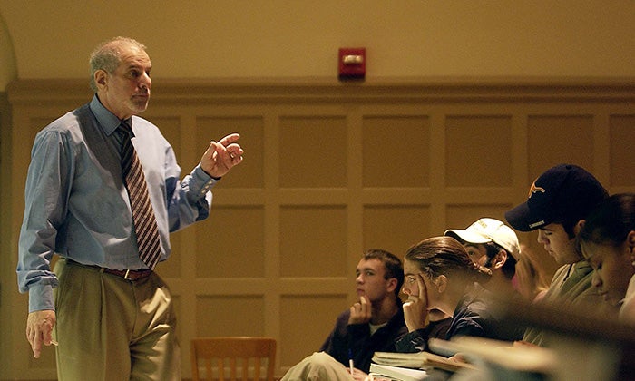 A professor lectures students in an auditorium