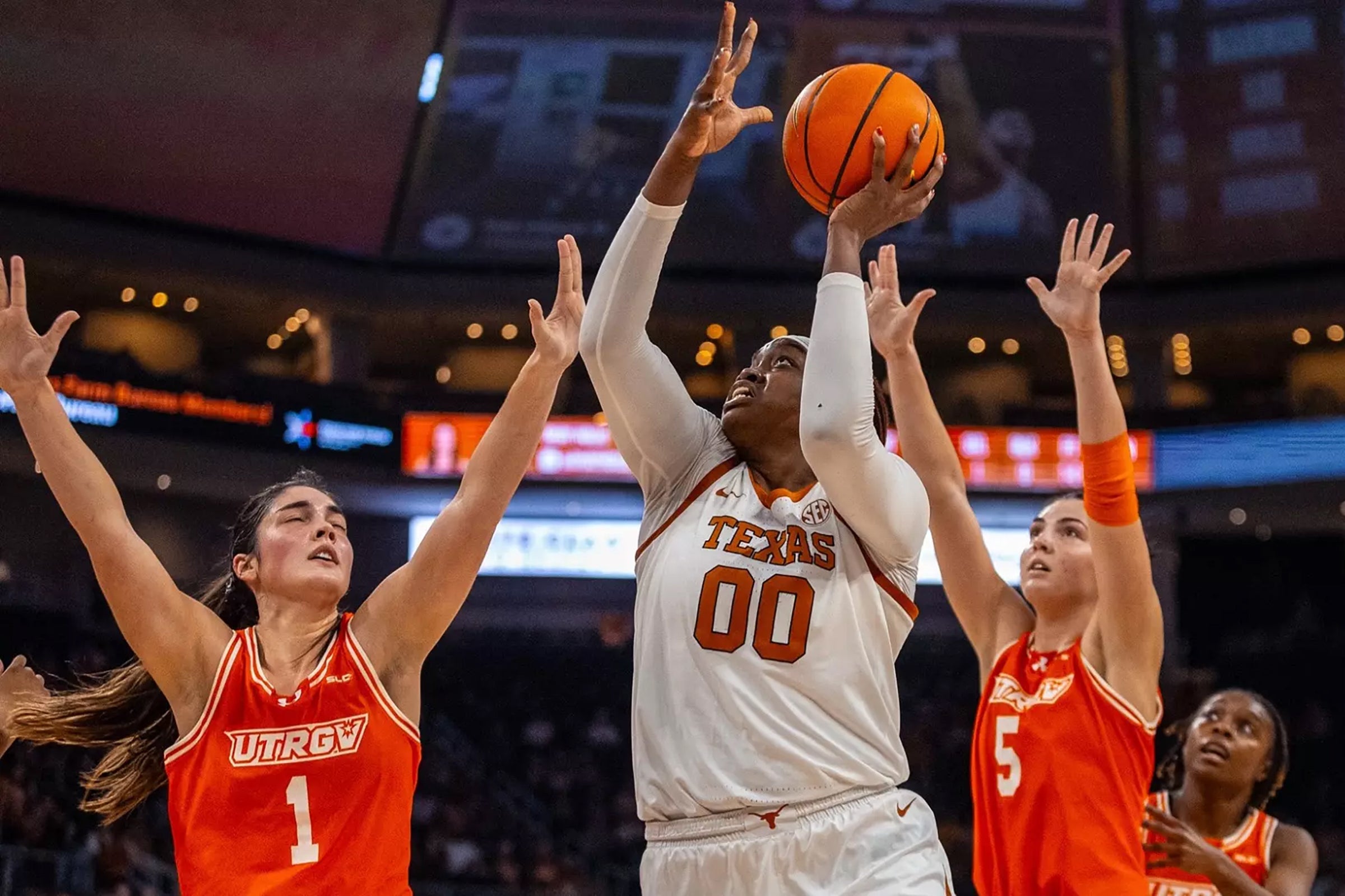 UT women's basketball player Kyla Goldacre takes a shot while surrounded by UT RGV players.