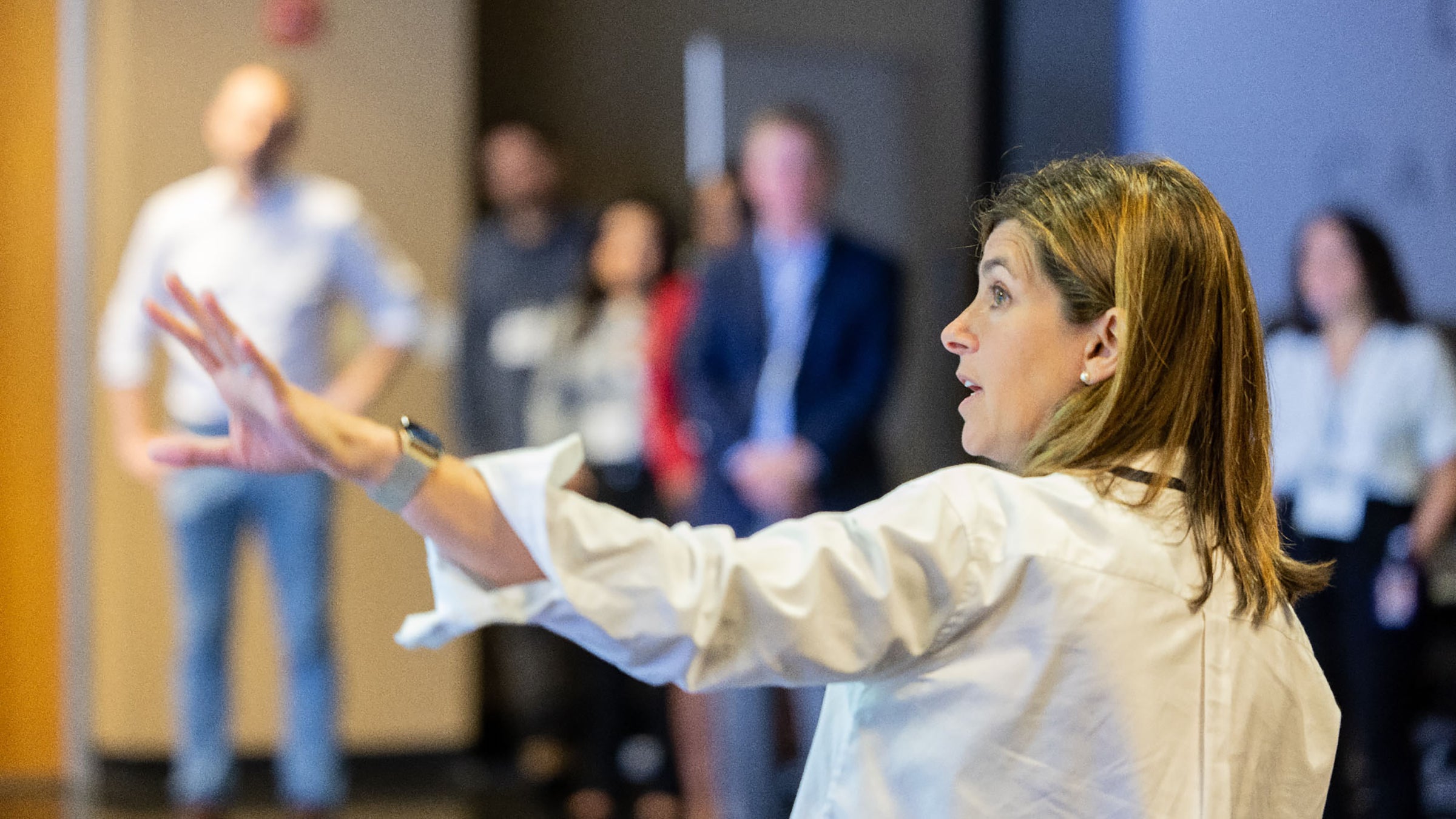 A scientist points to a pandemic model visualization in front of a standing audience