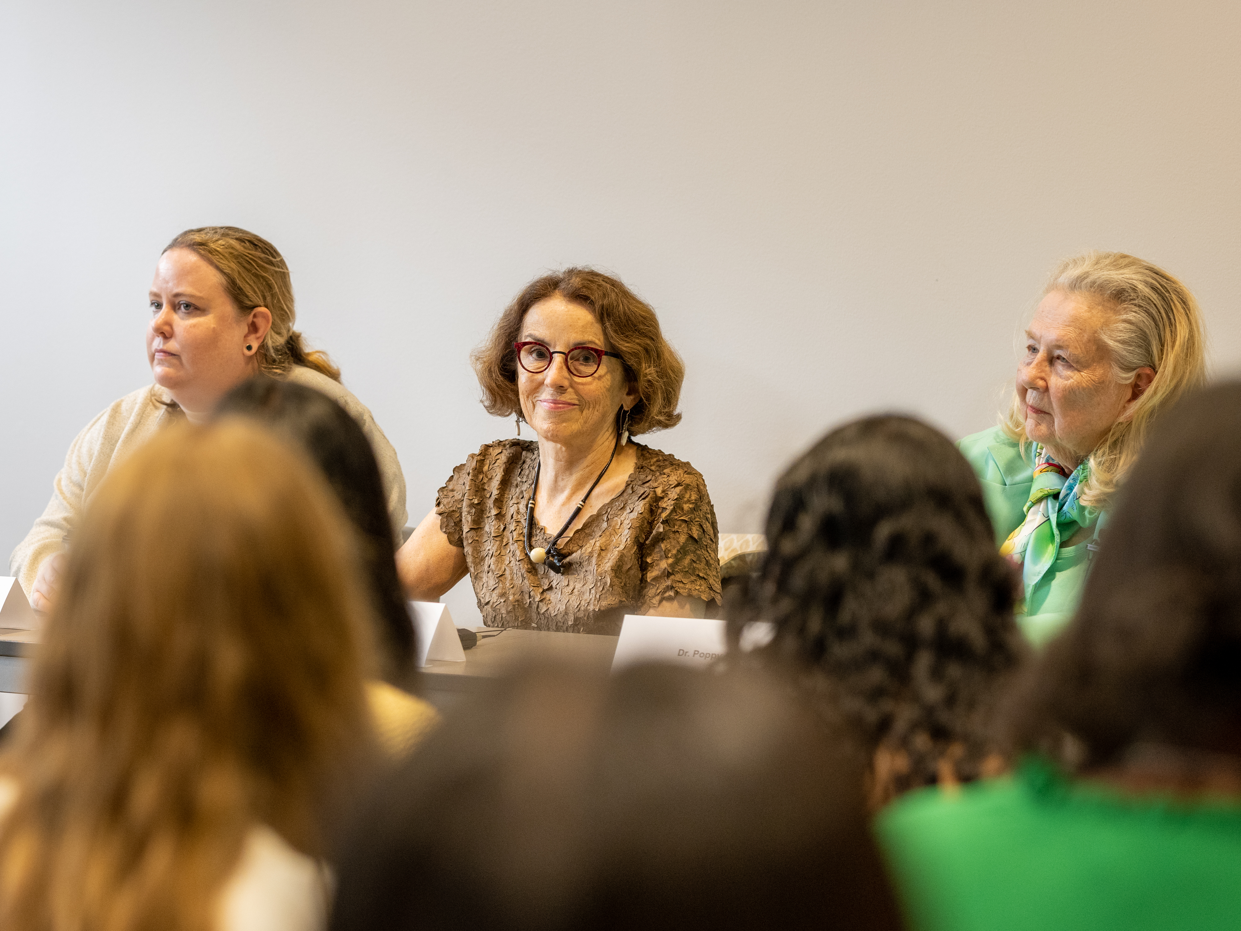 Three women in a panel discussion with an audience in front of them